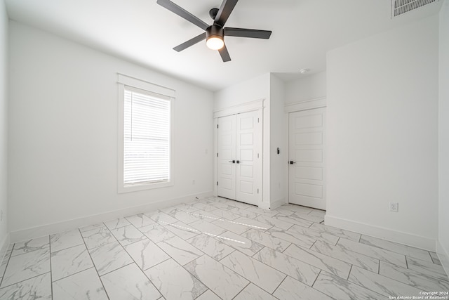 unfurnished bedroom with ceiling fan and a closet