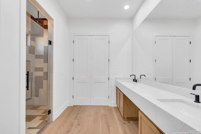 bathroom featuring vanity, hardwood / wood-style flooring, and a shower with shower door