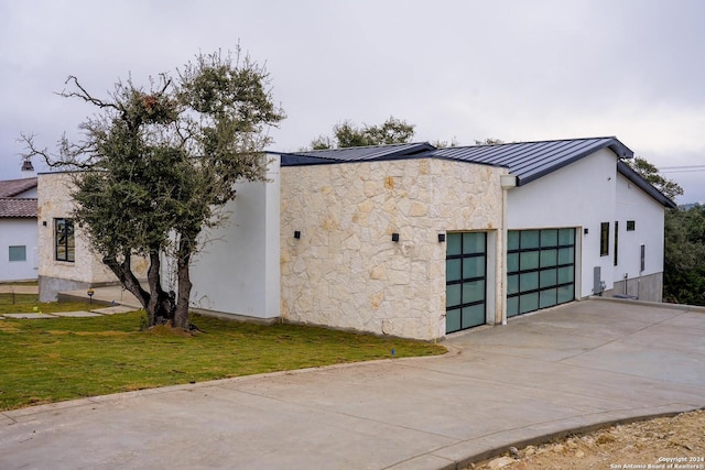 view of property exterior with a garage and a lawn