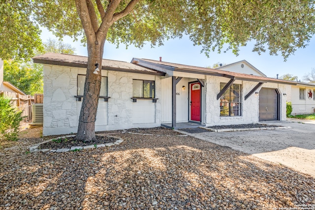 single story home featuring central AC and a garage