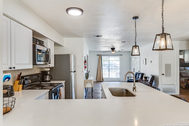 kitchen with backsplash, stainless steel appliances, dark wood-type flooring, sink, and hanging light fixtures