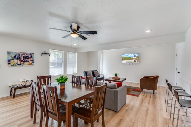 dining room featuring ceiling fan, a textured ceiling, and light hardwood / wood-style flooring