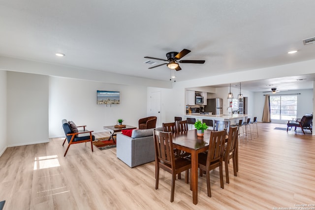 dining space featuring ceiling fan and light wood-type flooring