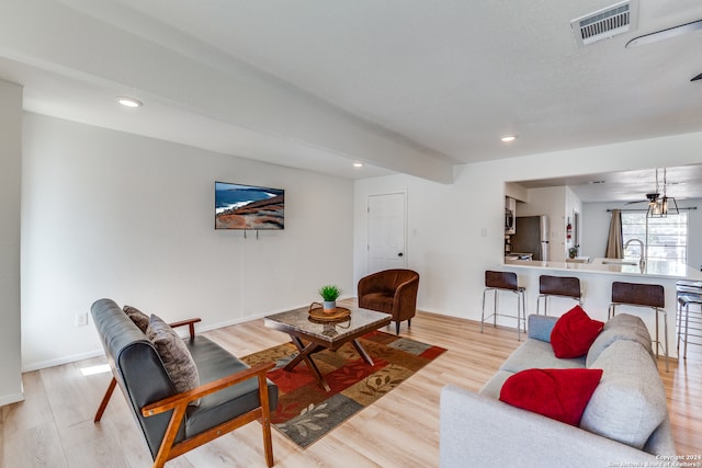 living room with ceiling fan and light hardwood / wood-style floors