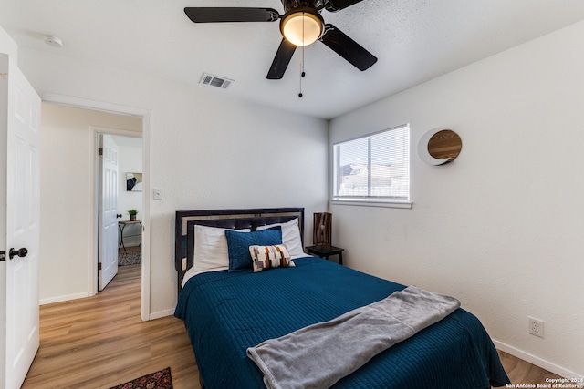 bedroom with ceiling fan and wood-type flooring