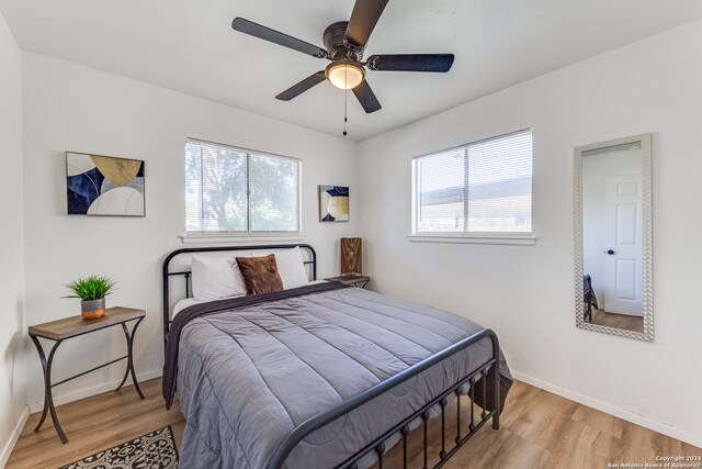 bedroom featuring light hardwood / wood-style flooring, multiple windows, and ceiling fan