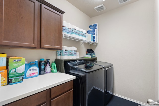 washroom featuring washer and dryer and cabinets