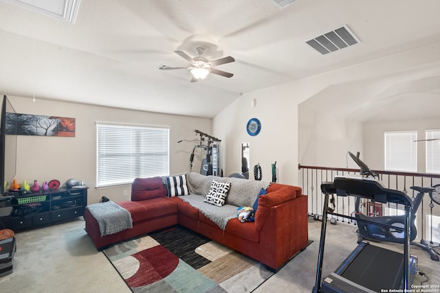 carpeted living room with ceiling fan and vaulted ceiling