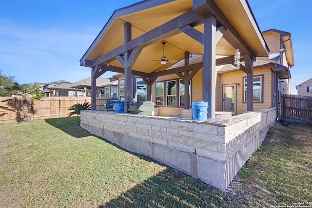 exterior space featuring ceiling fan and a yard