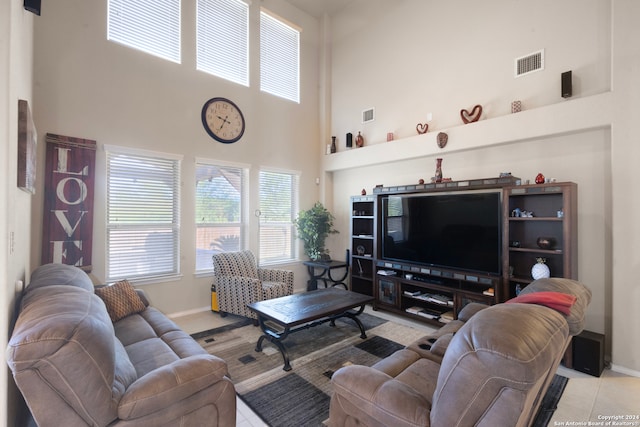 tiled living room featuring a towering ceiling