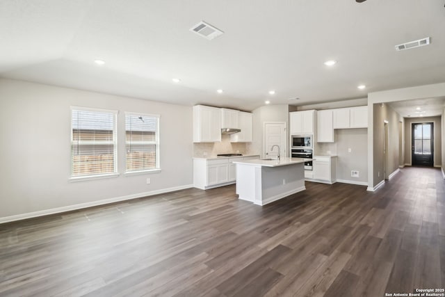 kitchen with stainless steel microwave, stovetop, visible vents, and wall oven