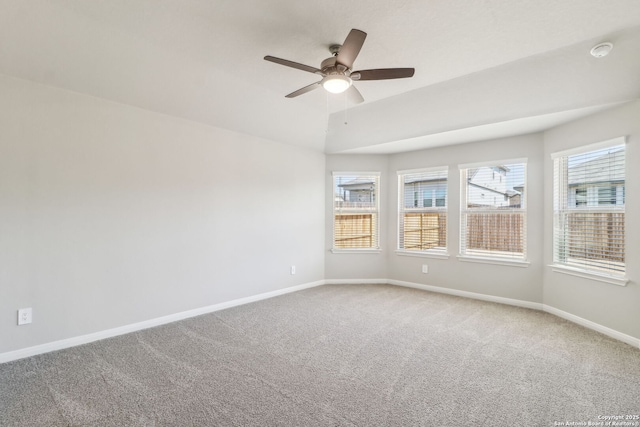 empty room with a ceiling fan, light colored carpet, and baseboards