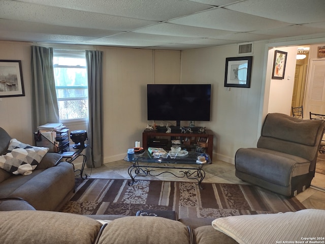 living area featuring baseboards, visible vents, and a drop ceiling