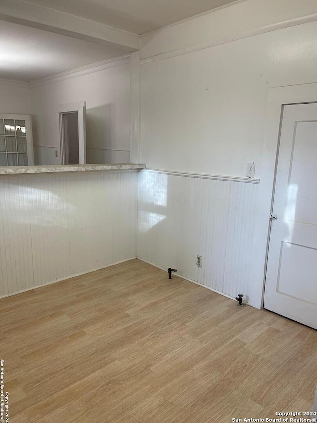 empty room featuring crown molding and light wood-type flooring