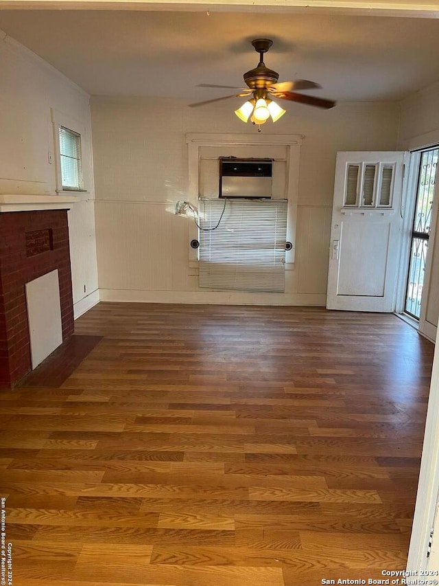 unfurnished living room featuring hardwood / wood-style flooring, ceiling fan, and a fireplace