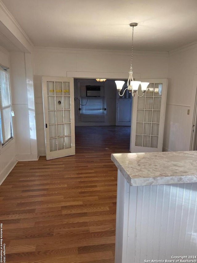 kitchen featuring a notable chandelier, decorative light fixtures, dark hardwood / wood-style flooring, and ornamental molding