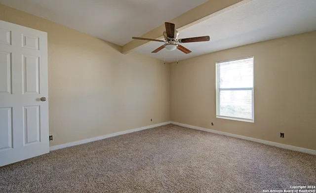 carpeted spare room with beam ceiling