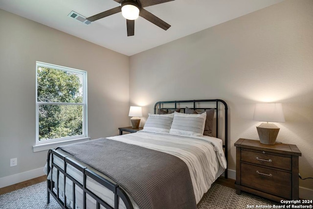 bedroom with ceiling fan, light hardwood / wood-style flooring, and multiple windows