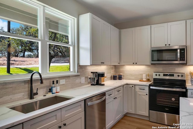 kitchen featuring white cabinets, stainless steel appliances, and a wealth of natural light