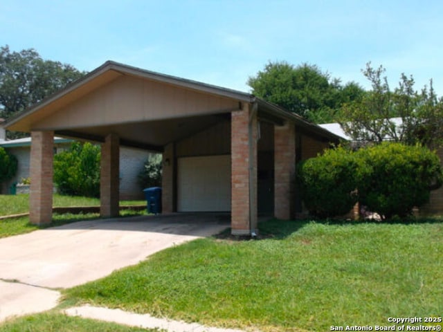 view of property exterior featuring a lawn, a garage, and a carport