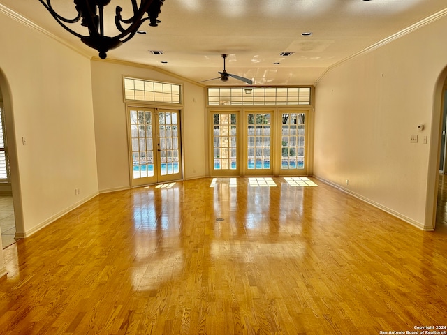 empty room featuring french doors, light wood-type flooring, ceiling fan, and ornamental molding