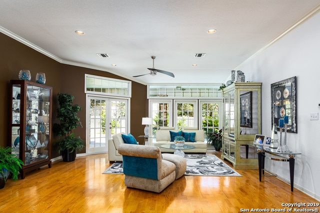 living room with french doors, light hardwood / wood-style floors, ceiling fan, and ornamental molding