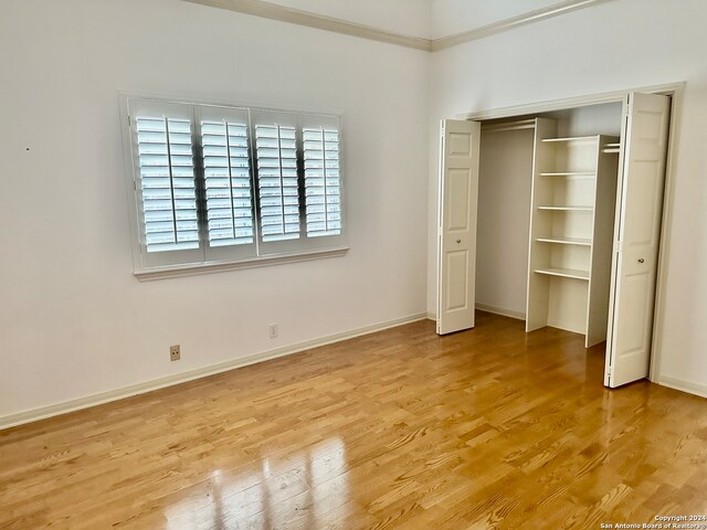 unfurnished bedroom with a closet and light hardwood / wood-style floors