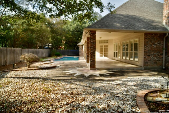 exterior space with a fenced in pool and a patio