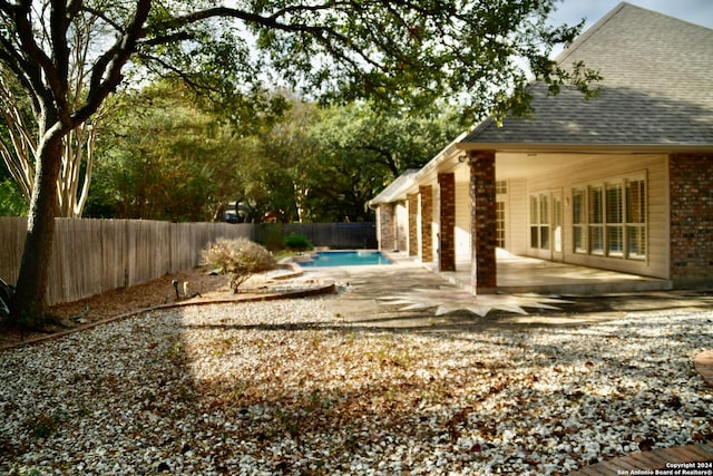 view of yard featuring a fenced in pool and a patio