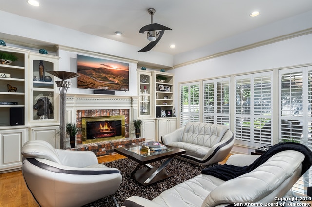 living room with light hardwood / wood-style flooring and a brick fireplace