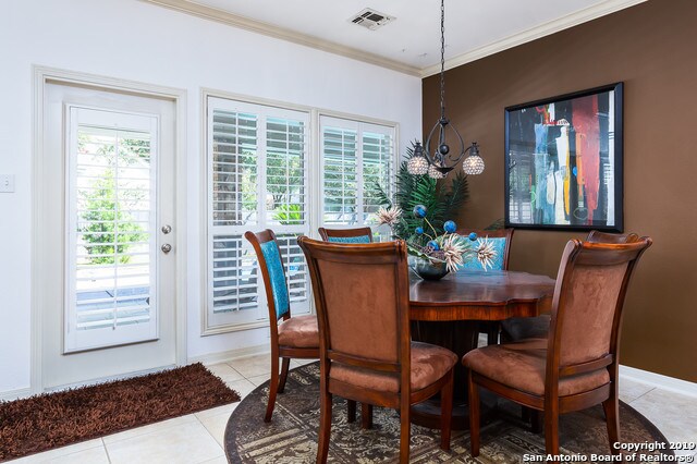 dining room featuring light tile patterned flooring and ornamental molding