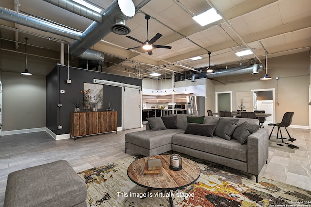 living room featuring ceiling fan, wood-type flooring, and a high ceiling