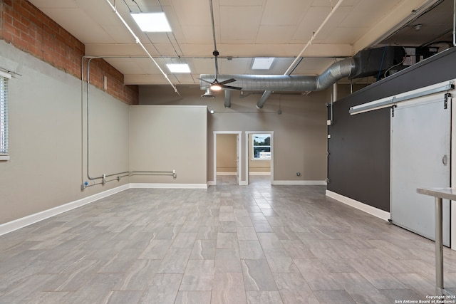 basement featuring a barn door and ceiling fan