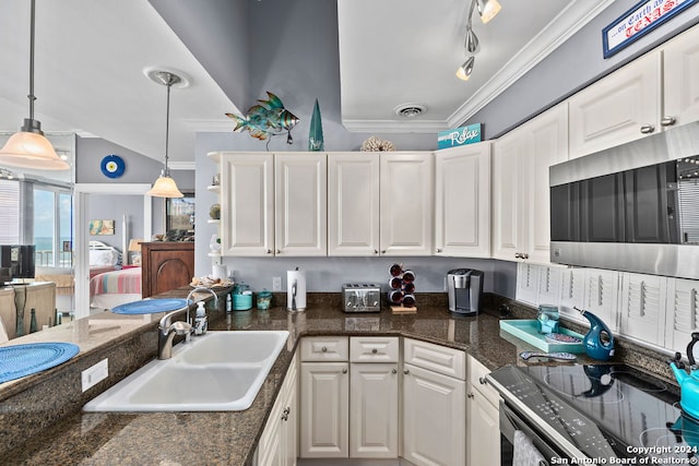 kitchen with sink, vaulted ceiling, ornamental molding, decorative light fixtures, and white cabinetry