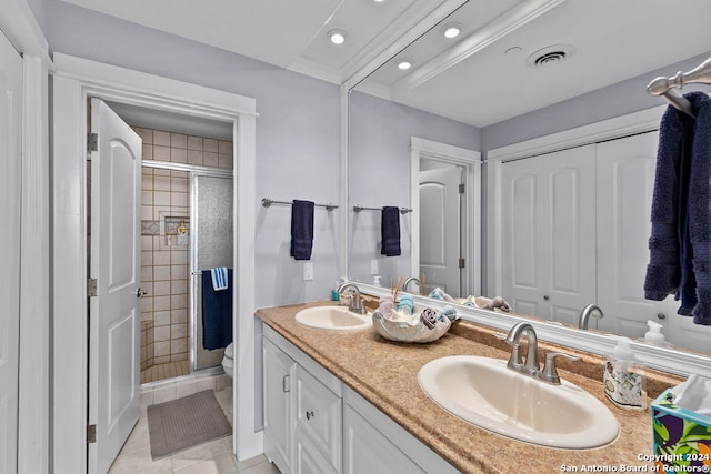 bathroom featuring tile patterned floors, vanity, toilet, and a shower with door