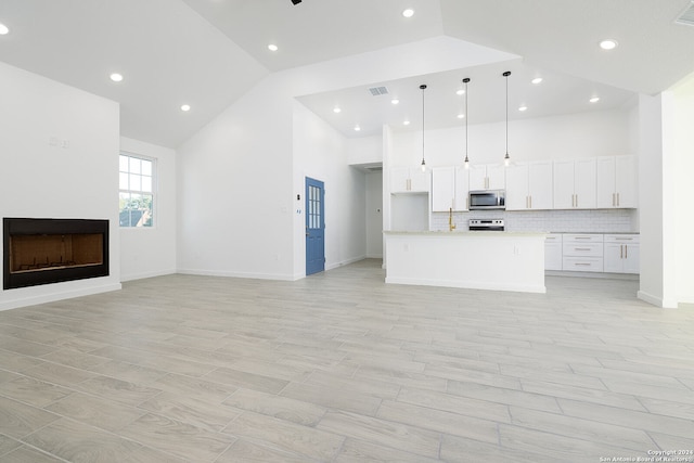 unfurnished living room featuring light hardwood / wood-style floors and high vaulted ceiling