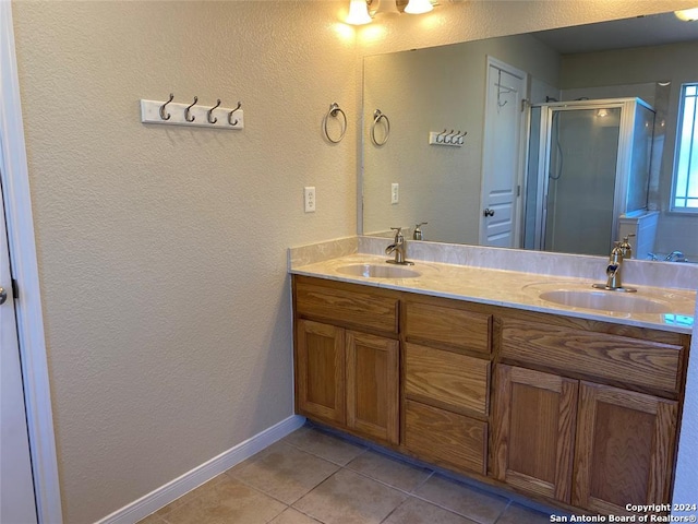 bathroom featuring tile patterned floors, vanity, and a shower with door