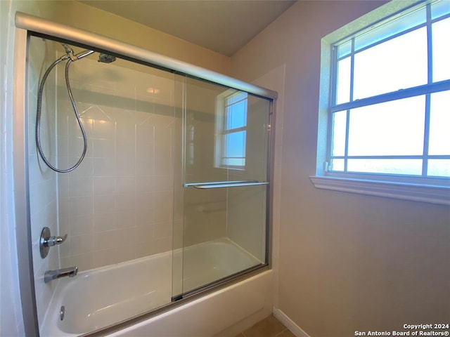 bathroom featuring bath / shower combo with glass door