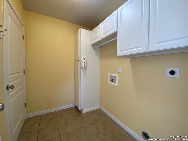 laundry area with hookup for an electric dryer, cabinets, light tile patterned floors, and hookup for a washing machine