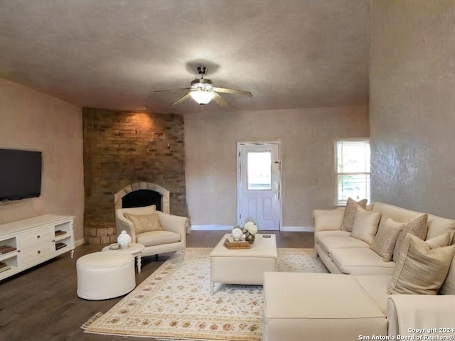 living room featuring a fireplace, dark hardwood / wood-style flooring, and ceiling fan