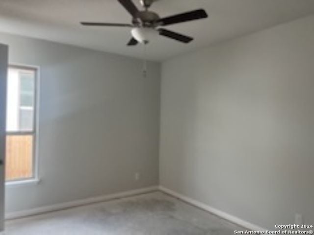 spare room with ceiling fan and baseboards