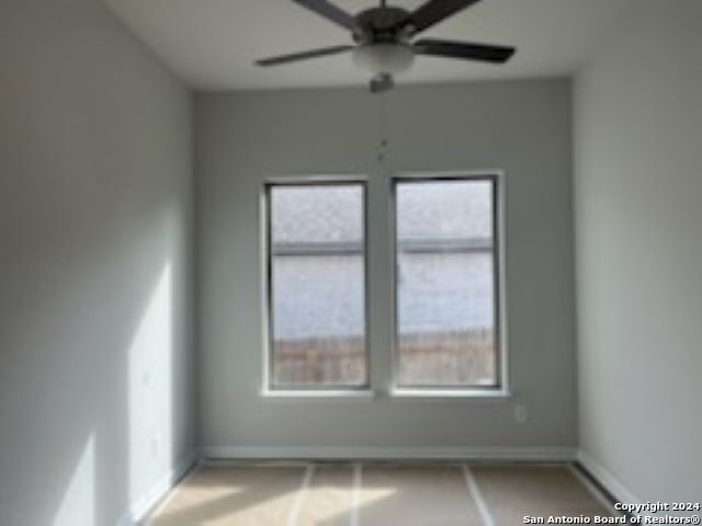 spare room with plenty of natural light, baseboards, and ceiling fan