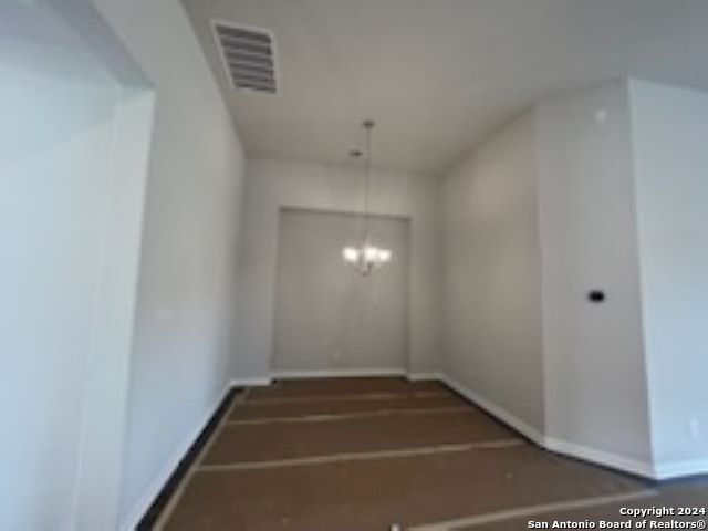 staircase featuring a chandelier, visible vents, and baseboards