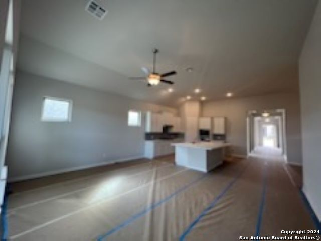 kitchen with open floor plan, a kitchen island, and white cabinets