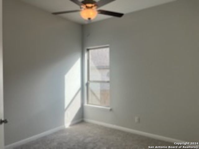 unfurnished room featuring a ceiling fan, carpet flooring, and baseboards