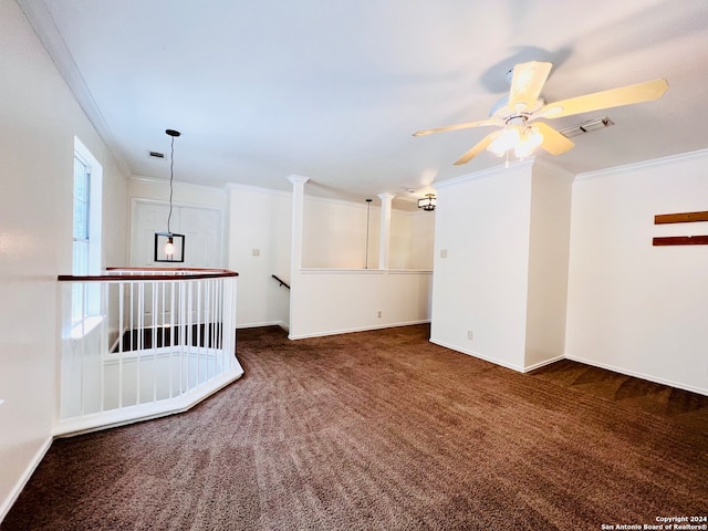 unfurnished room featuring dark colored carpet, ceiling fan, and crown molding