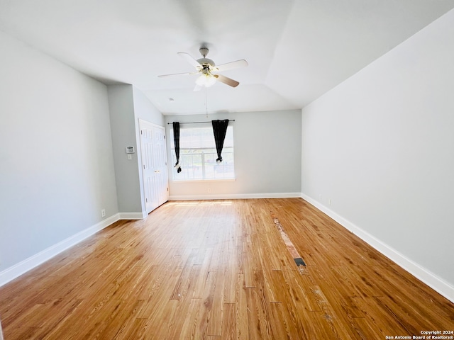 empty room featuring ceiling fan, light hardwood / wood-style flooring, and vaulted ceiling