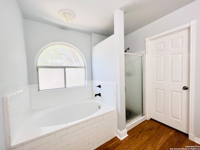 bathroom with wood-type flooring and independent shower and bath