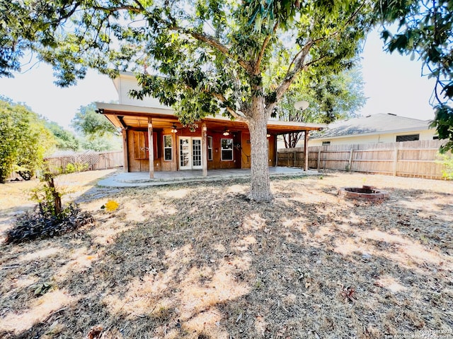 back of house featuring french doors, a patio, and a fire pit