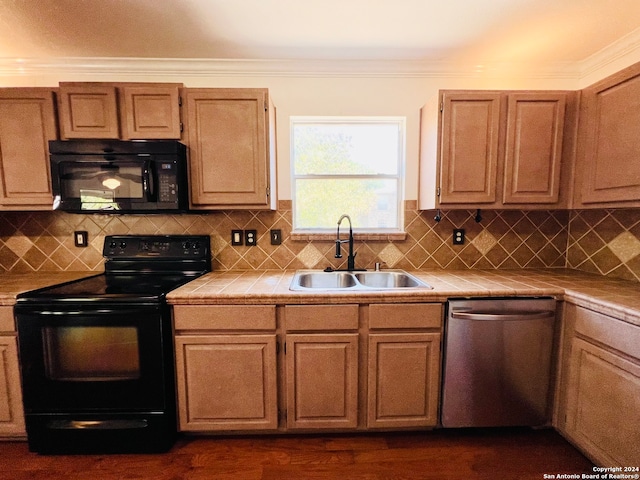 kitchen featuring backsplash, tile countertops, sink, and black appliances